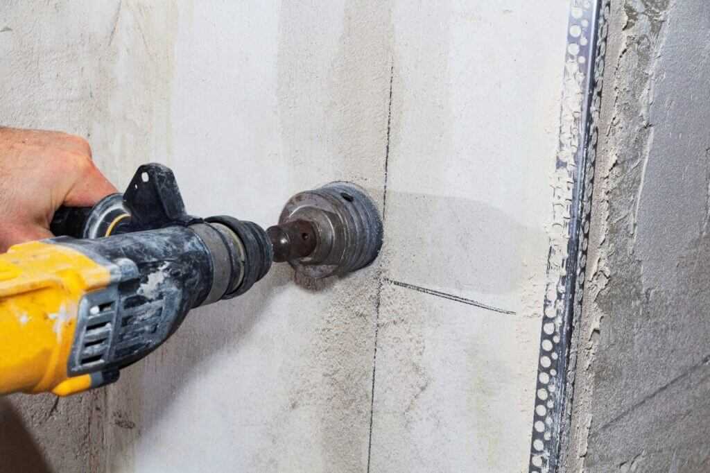 A man drilling concrete wall with a machine in Texas and Louisiana