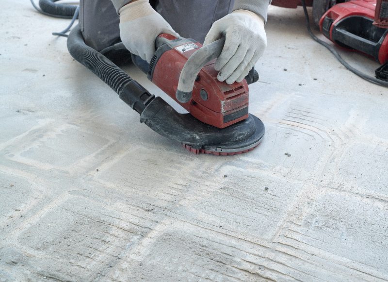 A person using a grinder on the floor