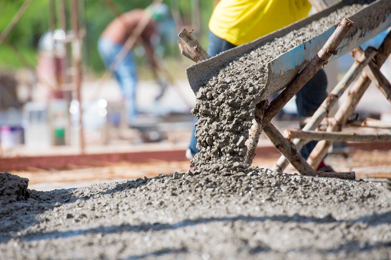 A person pouring cement into a foundation