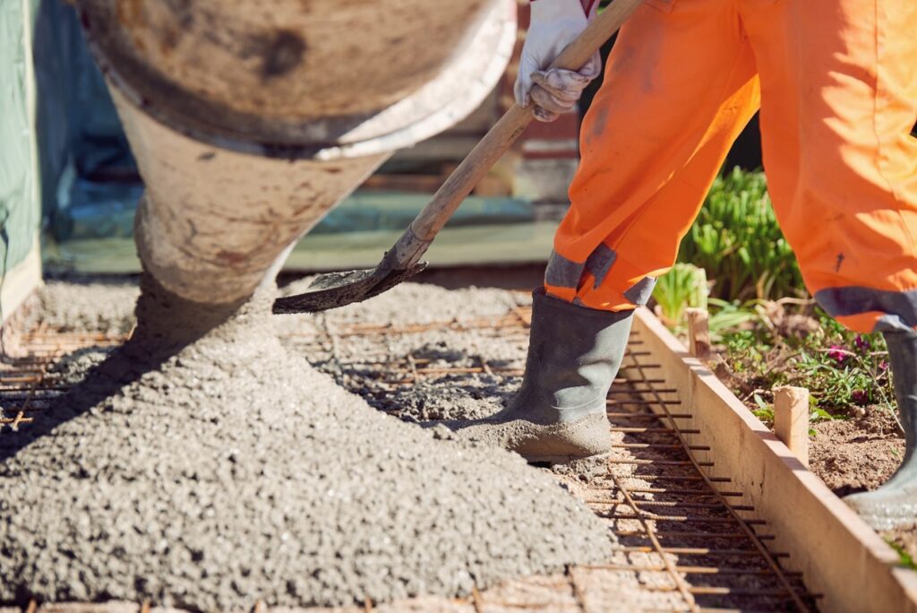 Construction worker using a shovel to mix cement